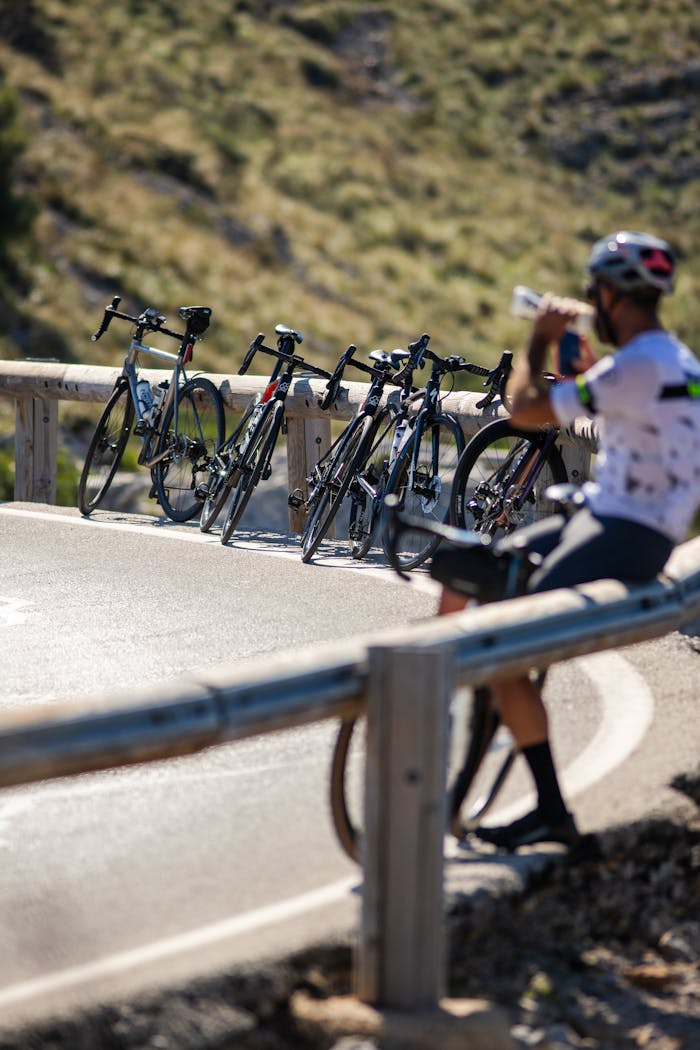 services-01 Cyclists taking a break on the picturesque roads of Sa Calobra, Spain, with bikes lined up along the road.