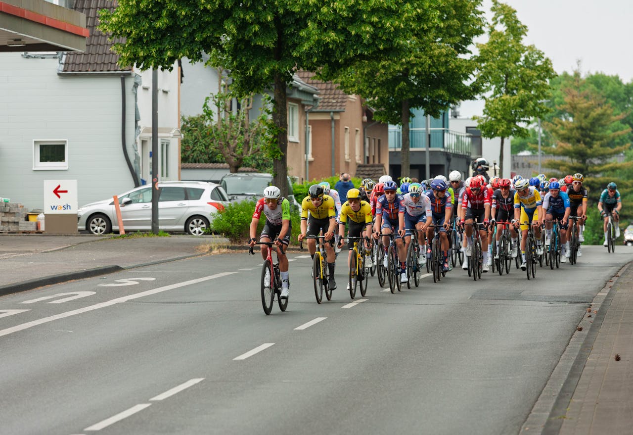 our-journey-02 Cyclists in a high-speed competition racing through an urban area, showcasing athletic endurance and team strategies.